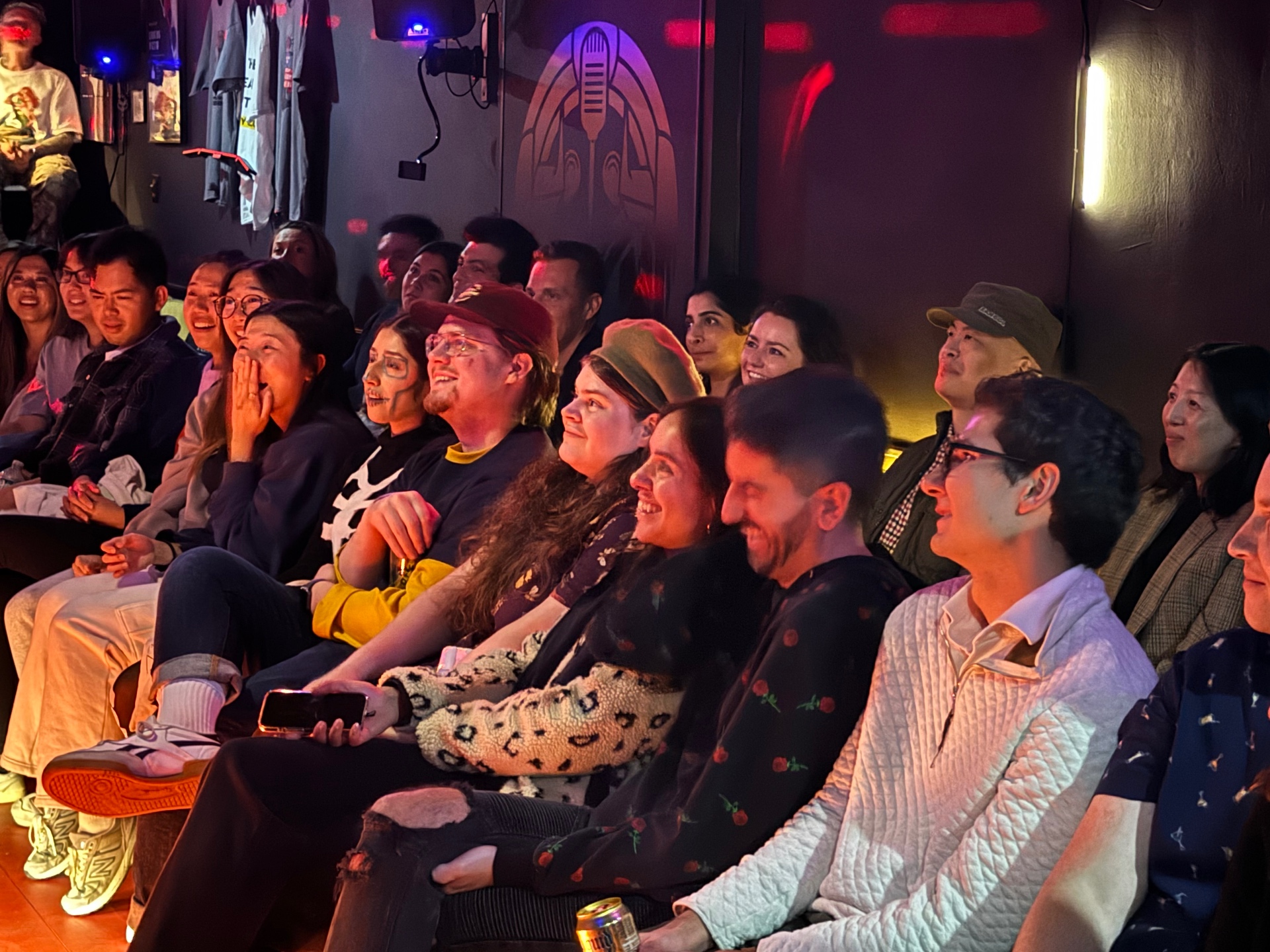 Smiling crowd watching stand-up comedy